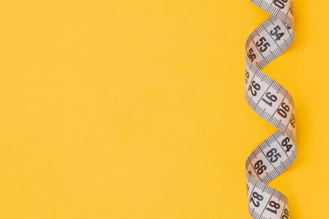 Measuring Tape on Yellow Background