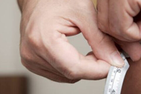 Man measuring his waist with tape